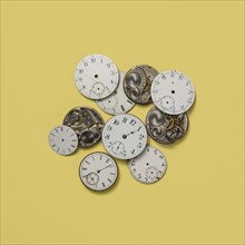 Retro watch faces and gears on yellow background