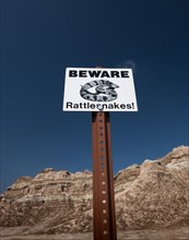 USA, South Dakota, Badlands National Park, Beware of Rattlesnakes sign in badlands