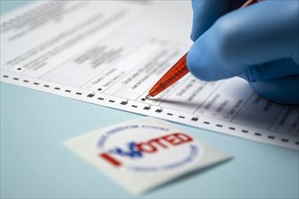 Badge and hand filling voting form on blue background