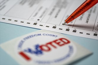 Voting form with pen and badge on blue background