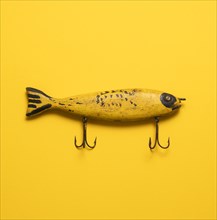 Antique yellow fishing lure on yellow background