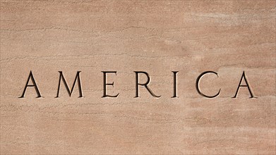 Word America engraved into stone surface