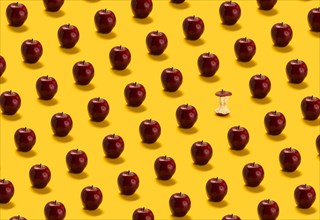 Large group of red apples on yellow background