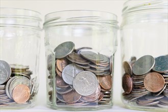 Jars with money on white background