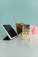 Studio shot of popcorn with digital tablet and soda