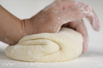 Close up of hand kneading dough