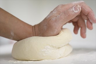 Close up of hand kneading dough
