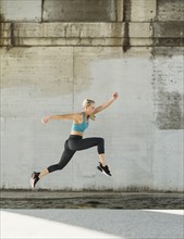 Sporty woman jumping outdoors
