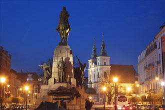 Poland, Lesser Poland, Krakow, Monument with statues on illuminated old town square