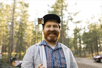 Portrait of smiling man holding roasted marshmallow on stick, Wasatch Cache National Forest