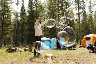 Man making large soap bubbles on camping, Wasatch-Cache National Forest