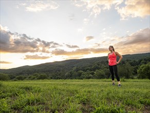 USA, Woman in running outfit standing in field