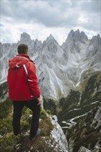 Italy, South Tirol, Belluno, Sexten Dolomites, Cadini di Misurina, Man standing at the edge of precipice looking at view
