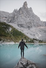 Italy, South Tyrol, Cortina d Ampezzo, lake Sorapis, Man standing on rock looking at lake