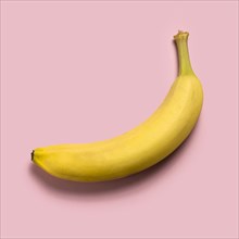 Ripe banana on pink background