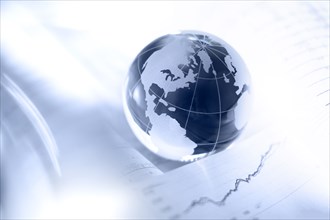 Glass globe and financial charts