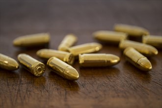 Gold bullets on wooden surface