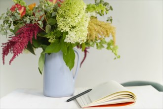 Notepad and flower bouquet on table