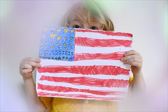 Boy (4-5) showing US flag drawn on paper