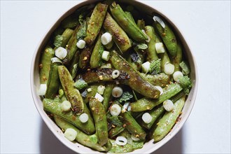 Cooked green peas with scallions and red pepper flakes