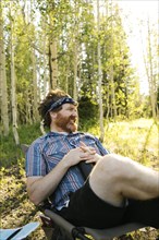USA, Utah, Uinta National Park, Man relaxing while camping in forest