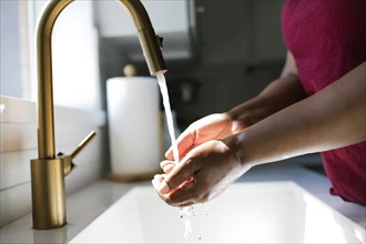 Close-up of woman washing hands in bathroom