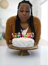 Woman blowing candles on birthday cake