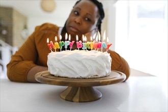 Portrait of woman behind birthday cake