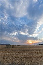 USA, Idaho, Bellevue, Bales of hay in field at sunset