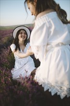 France, Young women in white dresses in lavender field