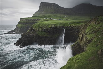 Denmark, Faroe Islands, Gasadalur village, Mulafossur Waterfall, Mulafossur Waterfall falling from cliff into ocean