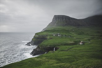 Denmark, Faroe Islands, Gasadalur village, Mulafossur Waterfall, Cliffed coast and ocean