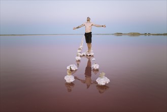 Ukraine, Crimea, Man standing on salt crystal in salt lake