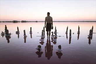 Ukraine, Crimea, Man standing in salt lake and holding camera