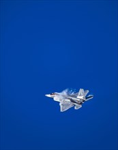 Lockheed Martin F-22 Raptor flying against blue sky