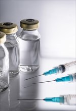 Studio shot of laboratory vials with liquid and syringes