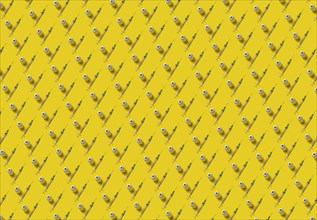 Rows of laboratory vials and syringes on yellow background