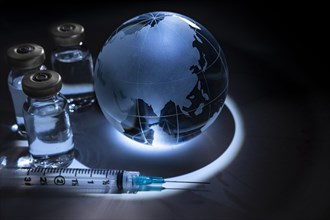 Glass globe with vials and syringe