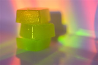 Stack of edible cannabis gummies in rainbow light