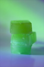 Stack of edible cannabis gummies in green light