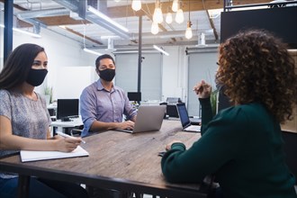 People in face masks having meeting in office