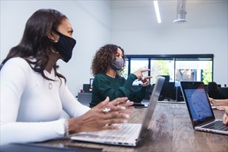 People in face masks having meeting in office