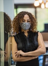 Portrait of woman in face mask standing in office