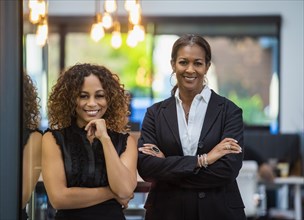 Portrait of two smiling businesswomen standing in office