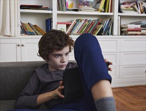 Boy (8-9) using tablet at home