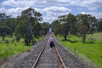 Woman hiking along railroad track