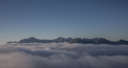 Mountain range and clouds under clear sky