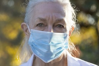 Portrait of senior female medical staff in covid protective mask