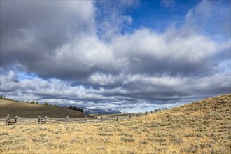 Ranch landscape with clouds and mountains in distance