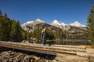 Senior woman standing by Taggart Lake in Grand Teton National Park